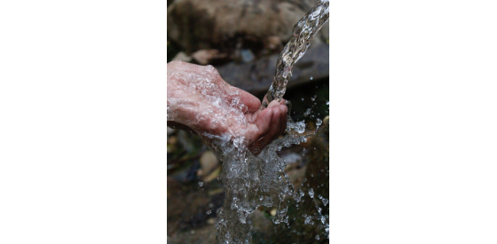 Hand under clear water steam