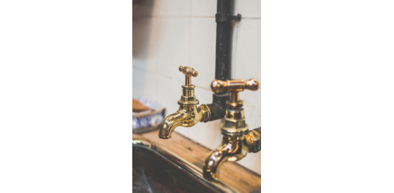 two brown taps placed above sink adjacent to wooden worktop