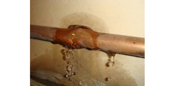 Pipe leaking with water pouring out of it
