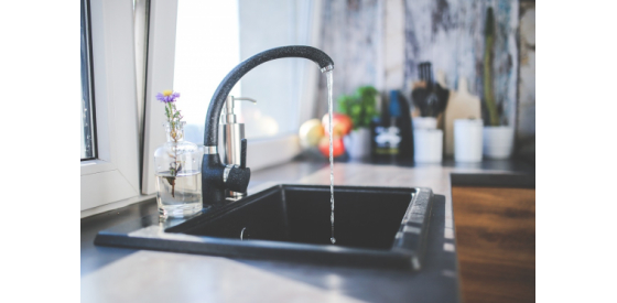 Black Faucet running with water into a sink