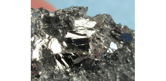 Antimony is shown as a silvery gray rock that appears to be a metal.