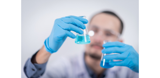 Chemist holding flask filled with blue liquid