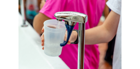 Person filling plastic cup with drinking water that may have epichlorohydrin in it